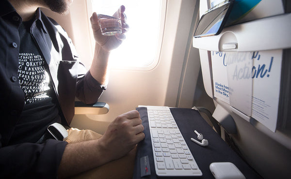 A Shepherd's Wool Utility Cloth spread out under a keyboard on an airplane tray table.